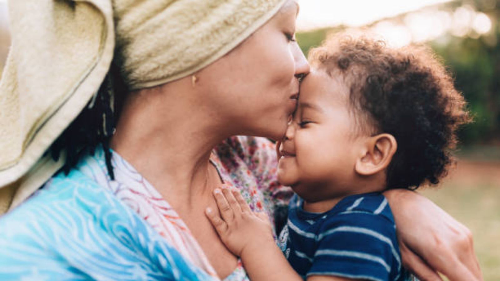 A grandmother kissing her smiling grandson